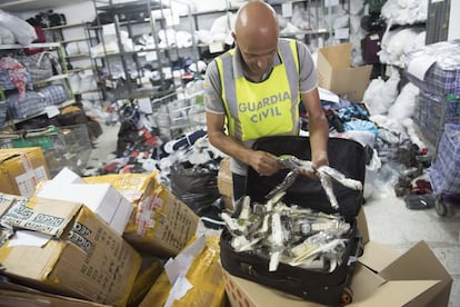Un agente de la Guardia Civil muestra una maleta rellena de cientos de relojes. Son copias de modelos de marcas famosas. Los agentes aprehendieron la maleta en la valla de la frontera de Algeciras por donde tratan de pasar todo tipo de artículos falsos.