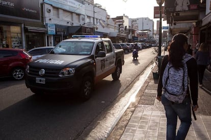 Un coche de la policía recorre una calle comercial de Martínez, en la periferia norte de Buenos Aires.