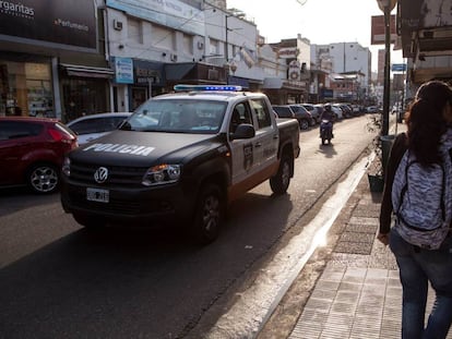 Un coche de la policía recorre una calle comercial de Martínez, en la periferia norte de Buenos Aires.