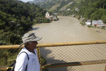 Un hombre cruza por un puente sobre el río Cauca durante la evacuación preventiva por las pruebas de Hidroituango.