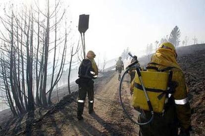 Un retén camina por una zona quemada en el incendio declarado el pasado sábado en Trabadelo (León).