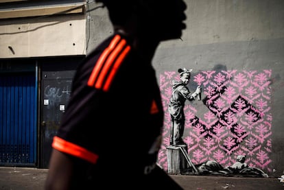 Un hombre camina frente a una obra supuestamente realizada por Banksy, el 24 de junio de 2018 en París. 