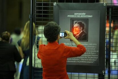 Una asistente al Congreso Espírita Mundial fotografía a uno de los padres del movimiento en un cartel.