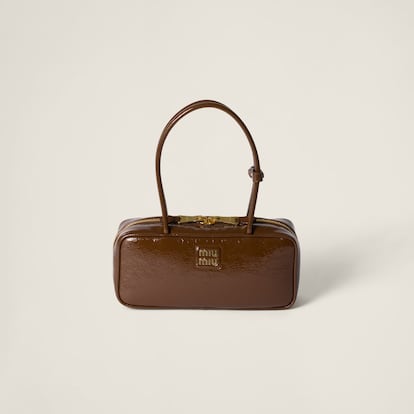 Miu Miu es la marca a la que acudir para encontrar una fusión de estética retro y contemporánea perfectamente ejecutada. Su bolso Beau es el accesorio en el que sintetizar toda la esencia de la marca italiana. Una original silueta de forma rectangular, en marrón chocolate y confeccionada en la piel naplak acharolada que termina de imprimirle su carácter único.