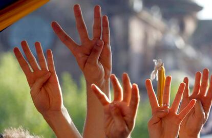 Un grupo de jóvenes independentistas muestran las cuatro barras de la bandera catalana con sus manos.