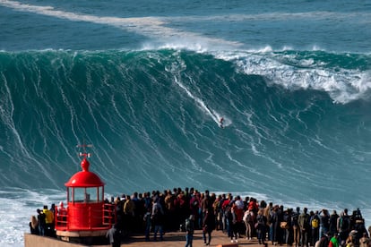 Decenas de aficionados observan al surfista Rodrigo Koxa en la playa de Nazaré (Portugal).