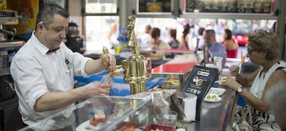 Un camarero atiende la barra en un bar