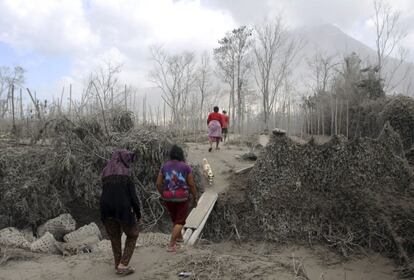 Granjeros observan sus tierras cubiertas de ceniza volcánica tras las erupciones del volcán Sinabung en la localidad de Sibitung en Karo al norte de Sumatra en Indonesia.