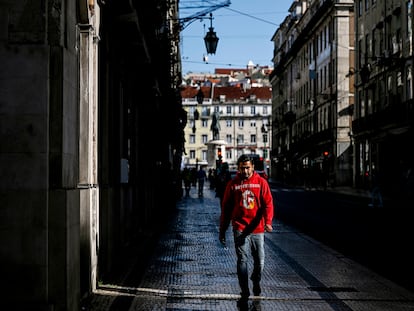 Un hombre camina por una calle de Lisboa.