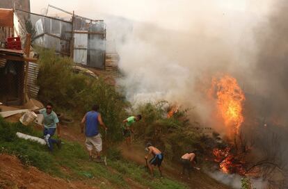 Para controlar el incendio en la región, se encuentran trabajando en el operativo 700 personas. En la imagen, vecinos trabajan con palas para evitar que el fuego alcance las casas.