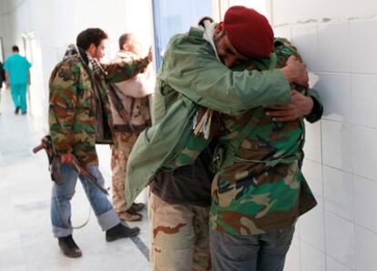 Tres rebeldes lloran la muerte de su amigo, Ibrahim El Felah en el hospital de Ajdabiya.