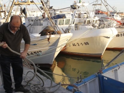 Un pescador amarra un bote en el puerto de Barbate.