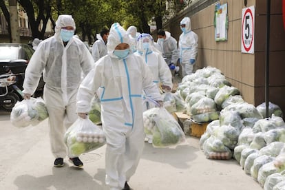 Un grupo de voluntarios se encargaba de llevar el lunes productos de necesidad básica a los residentes confinados en la parte oriental de Shanghái, conocida como Pudong.