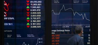 Un peat&oacute;n australiano, ante un monitor de cotizaciones.