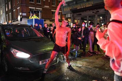 Un hombre se tira una bebida por el cuerpo en una calle del barrio del Soho, en Londres. La reapertura de pubs en Inglaterra, después de más de tres meses de confinamiento, provocó desmanes y situaciones "peligrosas" en la noche del sábado, y hace temer un rebrote de la epidemia.