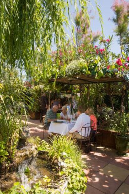 Comensales en el jardín de Les Grands Buffets.