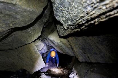 Los investigadores dicen que esta cueva se encuentra cerca del sitio donde, según la Biblia, la esposa de Lot se convirtió en un pilar de sal. En la imagen, una espeleóloga gatea para abrirse paso entre los recovecos de la caverna Malham.