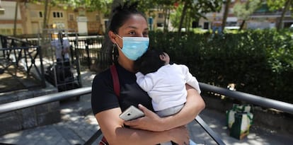 Una mujer con su bebé en brazos, acude a las puertas de la Parroquia Santa María Micaela para recibir una ayuda alimentaria.