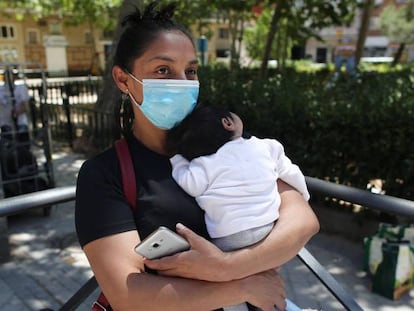 Una mujer con su bebé en brazos, acude a las puertas de la Parroquia Santa María Micaela para recibir una ayuda alimentaria.