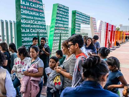 Migrantes centroamericanos deportados de EE UU esperan en el puesto fronterizo de El Chaparral a ser trasladados a un centro en Tijuana, el 22 de julio. 