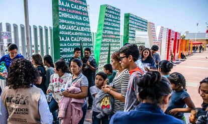 Migrantes centroamericanos deportados de EE UU esperan en el puesto fronterizo de El Chaparral a ser trasladados a un centro en Tijuana, el 22 de julio. 