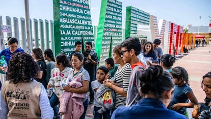 Migrantes centroamericanos deportados de EE UU esperan en el puesto fronterizo de El Chaparral a ser trasladados a un centro en Tijuana, el 22 de julio. 