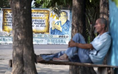 Un hombre descansa en una calle de Aracataca frente a un mural dedicado a García Márquez.