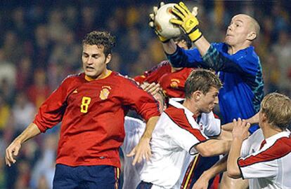 El portero de la selección noruega, E. Johnsen, atrapa el balón por encima de su defensa y ante el jugador de la selección española Rubén Baraja.