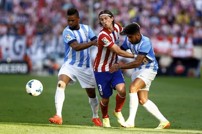 Filipe Luis entre dos jugadores del malaga