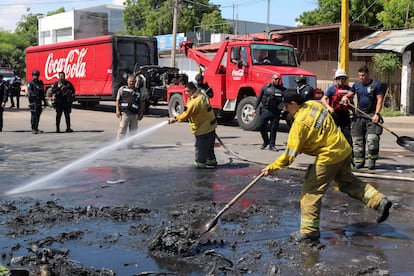 Bomberos en el sitio de la quema de un camión de distribución, el 11 de septiembre.