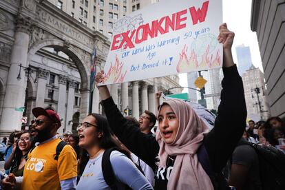 Una joven muestra una pancarta que lee "Exxon sabía que el mundo estaba ardiendo hace 50 años, pero lo negaron" en la manifestación de Nueva York, EE.UU.
