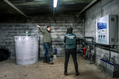 Un agente del Seprona inspecciona el interior del pozo del agricultor José David Garrido, en Iniesta (Cuenca). 