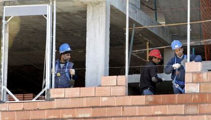 Tres obreros trabajan en una vivienda.