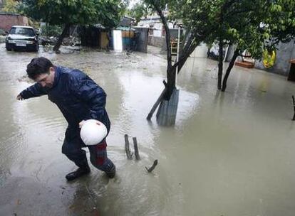 Un hombre intenta salir de un jardin anegado en la avenida de Vicálvaro, en Coslada, tras las lluvias de ayer.
