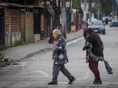 Una adulta mayor camina por la comuna de La Pintana en Santiago, Chile.