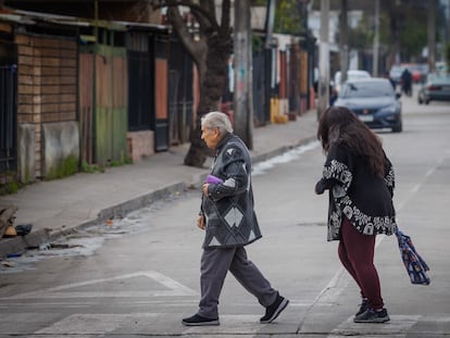 Una adulta mayor camina por la comuna de La Pintana en Santiago, Chile.