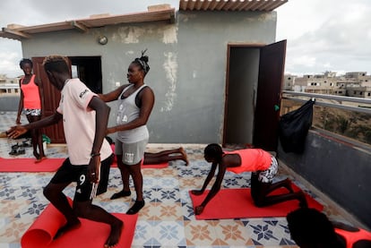 Khadjou Sambe instruye a un alumno durante una clase de gimnasia dentro de la escuela Black Girls Surf, que también admite varones, en Ngor, Dakar, Senegal, el 28 de julio de 2020. Una buena condición física es indispensable para poder coger olas.