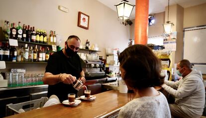 Dos personas toman café en la barra de un bar de la localidad sevillana de Mairena del Aljarafe.