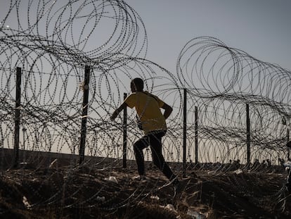 Un migrante cruza la valla fronteriza entre Ciudad Juárez y El Paso, el 10 de mayo de 2023.