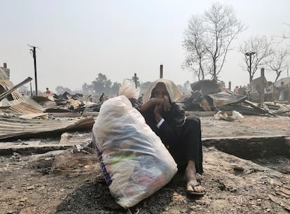 Una mujer rohinyá sentada en el suelo con sus pertenencias en una bolsa, tras el incendio que ha asolado el campamento Cox’s Bazar, en Bangladés.