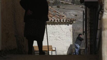 Una vecina del pueblo de Zafrilla (Cuenca) pase por una calle.