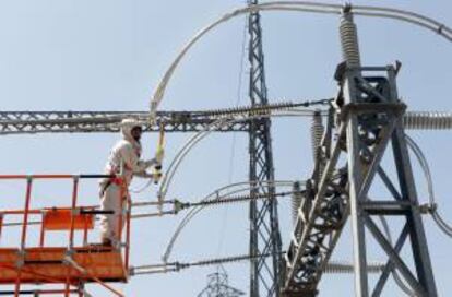 Un operario trabaja en un cable de alta tensión. EFE/Archivo