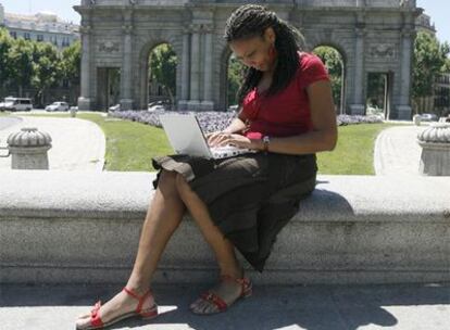 Una emprendedora extranjera consulta su ordenador en la Puerta de Alcalá (Madrid).