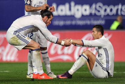 Gareth Bale ayuda a Cristiano Ronaldo a levantarse tras la falta de Savic que supuso el penalti para el Real Madrid. 