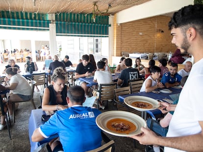 Un camarero atiende a los clientes en una terraza de un restaurante de Málaga.