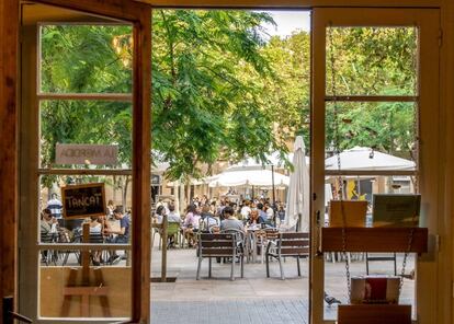 La plaça d’Osca, al barri barceloní de Sants, vista des de l'interior de la llibreria Barra/Llibre. 