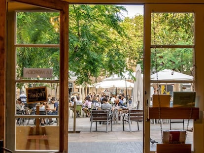 La plaça d’Osca, al barri barceloní de Sants, vista des de l'interior de la llibreria Barra/Llibre. 