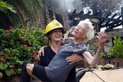 Kate Winslet bromea con un casco de bombero junto a Eve Branson, de 90 años