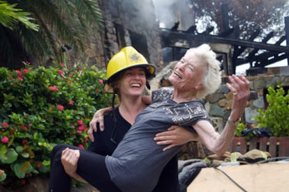 Kate Winslet bromea con un casco de bombero junto a Eve Branson, de 90 años