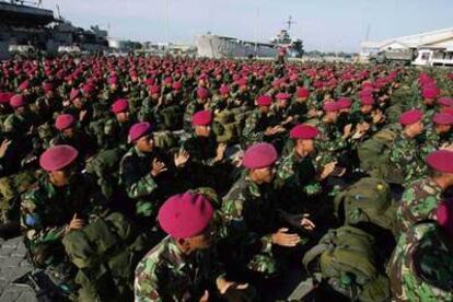 Soldados indonesios entonan un himno mientras esperan para embarcar en Aceh.